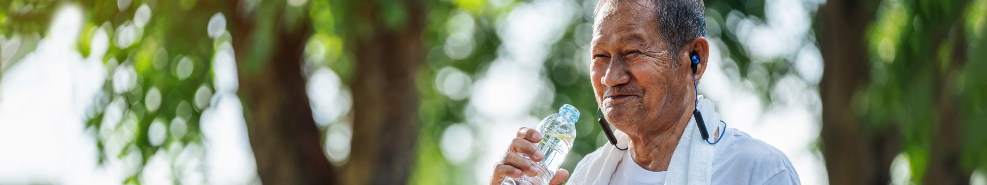 man smiling and drinking water after a work out